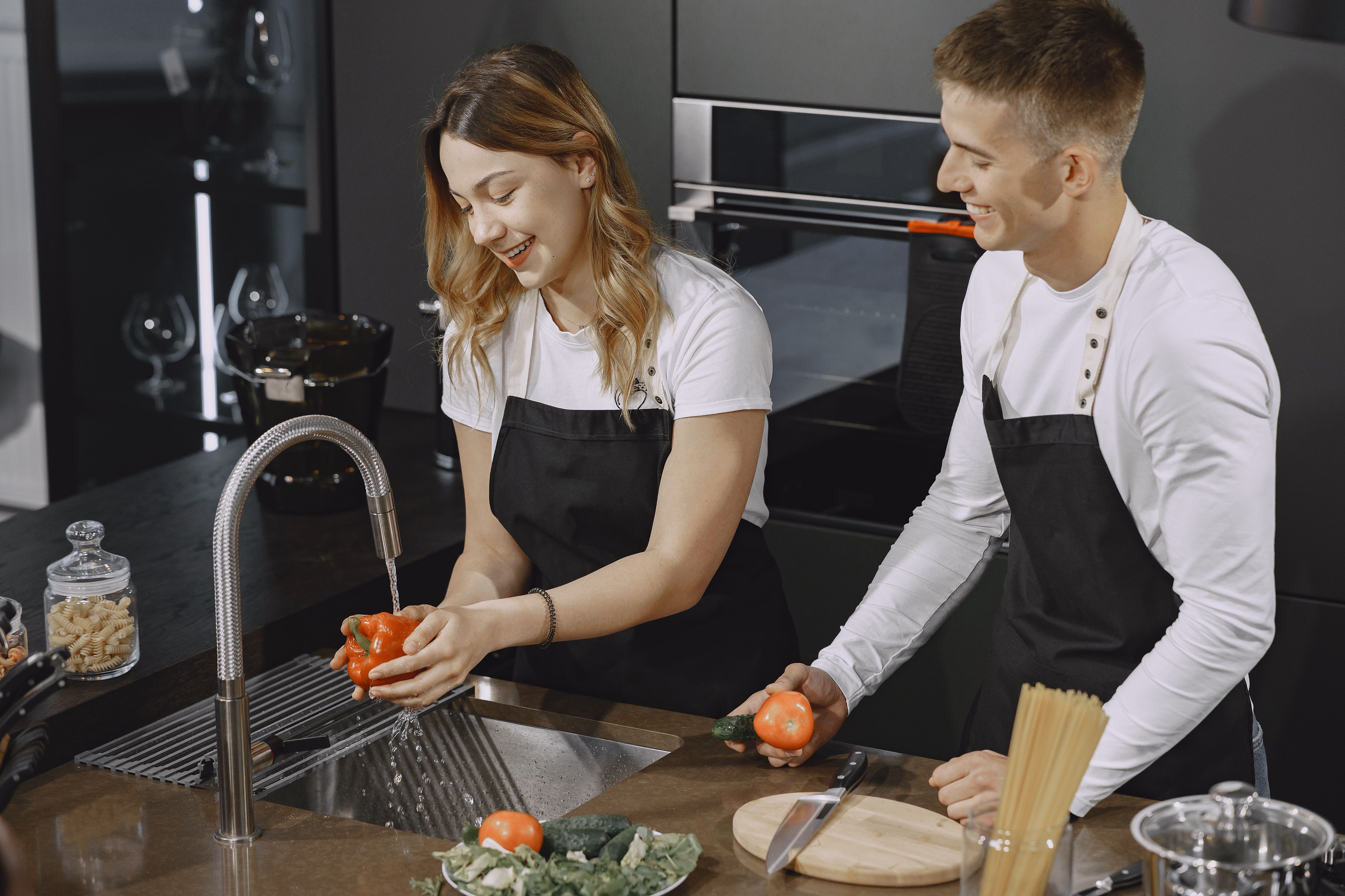Un couple prépare ensemble un repas de légumes dans une cuisine